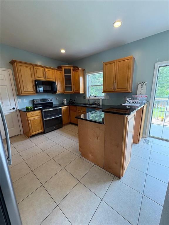 1951 Bergerac Ct SW, Marietta, GA 30008 - kitchen featuring double oven range, black microwave, a sink, dark countertops, and light tile patterned flooring