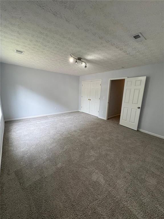 1951 Bergerac Ct SW, Marietta, GA 30008 - unfurnished bedroom featuring baseboards, dark carpet, and a textured ceiling