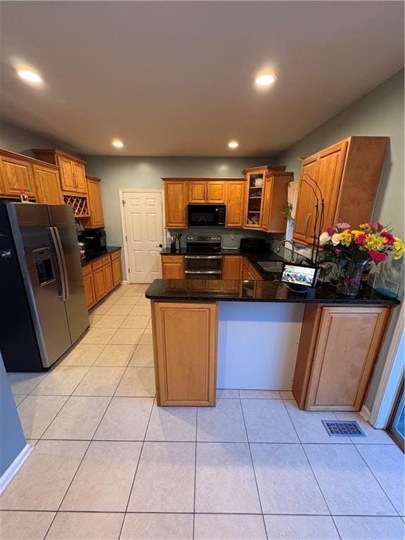 kitchen featuring black appliances, a peninsula, glass insert cabinets, brown cabinets, and recessed lighting