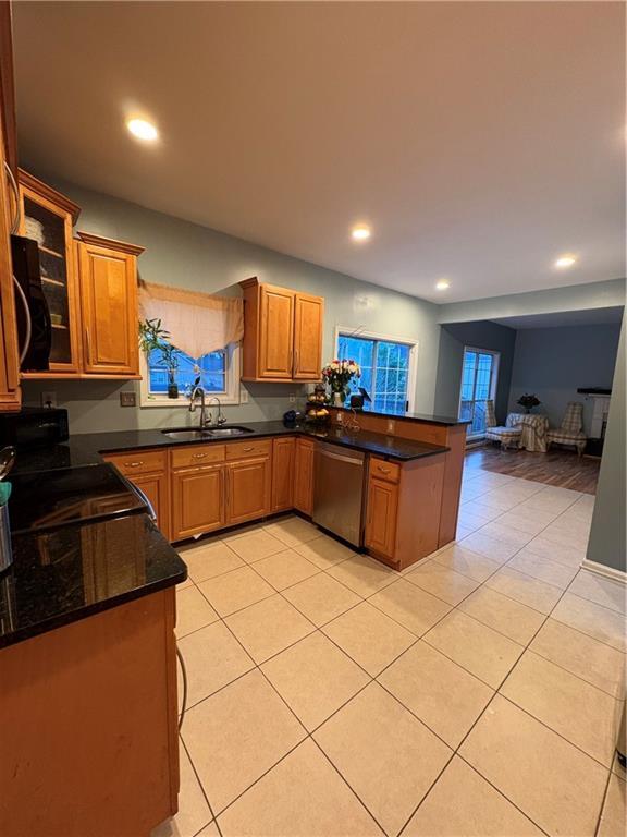 kitchen with dishwasher, a sink, a peninsula, light tile patterned floors, and recessed lighting