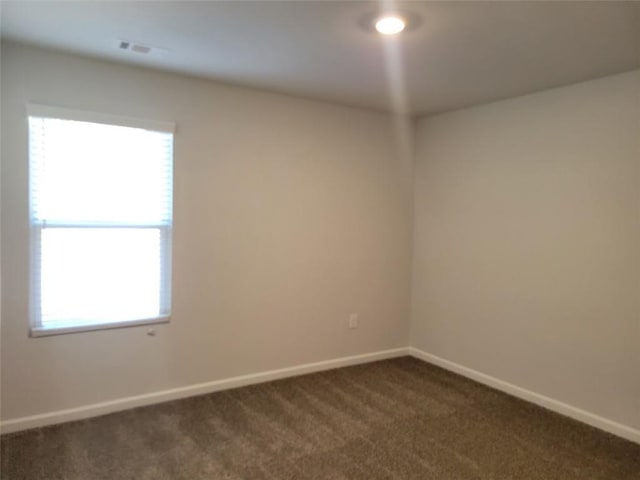 empty room featuring dark carpet