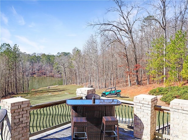 wooden deck with a water view and a lawn