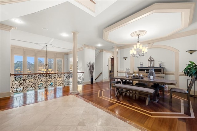 dining room with light tile patterned floors, ornate columns, ornamental molding, and a notable chandelier