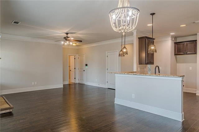 kitchen featuring pendant lighting, dark wood-type flooring, ornamental molding, light stone countertops, and ceiling fan with notable chandelier