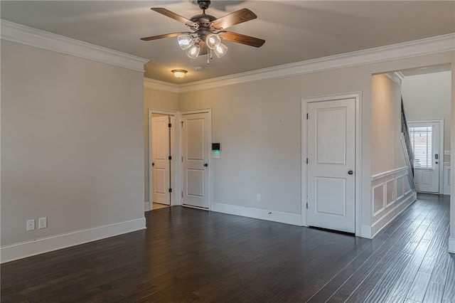 empty room featuring crown molding, dark wood-type flooring, and ceiling fan