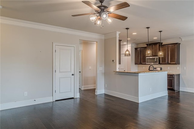 146 Blackgum Trce, Dallas, GA 30132 - kitchen with crown molding, dark brown cabinets, ceiling fan, stainless steel microwave, and backsplash