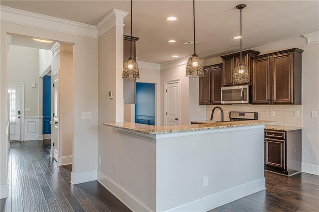 kitchen with pendant lighting, light stone countertops, stainless steel appliances, and kitchen peninsula