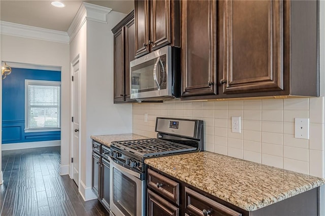 kitchen with dark brown cabinetry, light stone countertops, crown molding, and stainless steel appliances