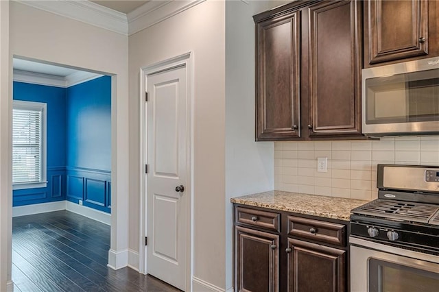 kitchen featuring dark brown cabinets, ornamental molding, stainless steel appliances, and dark hardwood / wood-style floors