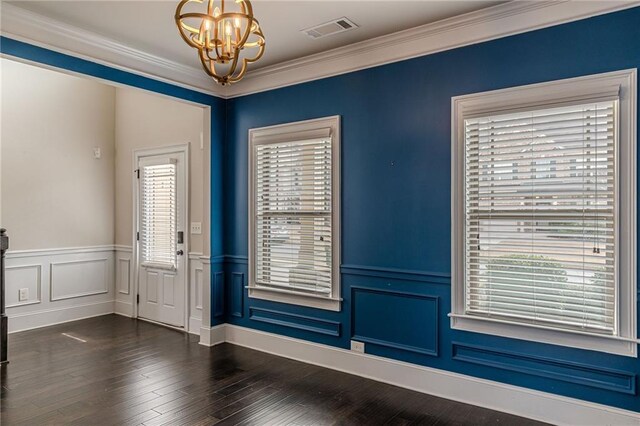 foyer entrance featuring a notable chandelier, dark wood-type flooring, and ornamental molding