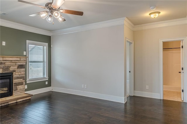 unfurnished living room with crown molding, ceiling fan, a stone fireplace, and dark hardwood / wood-style flooring