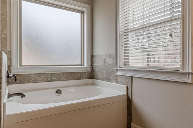 bathroom with a washtub and a healthy amount of sunlight