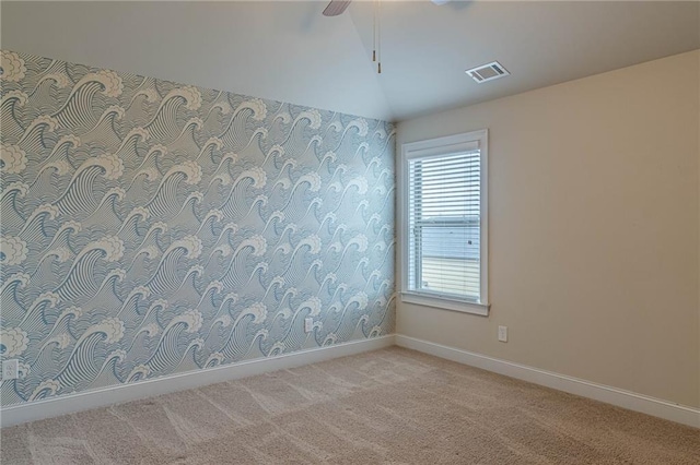 carpeted empty room with vaulted ceiling and ceiling fan