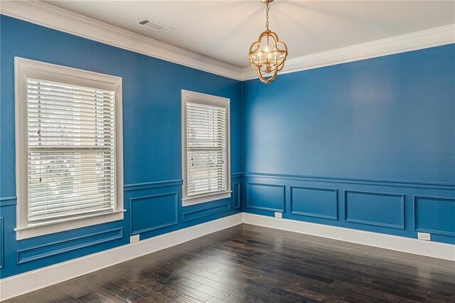 unfurnished room featuring ornamental molding, dark hardwood / wood-style floors, and an inviting chandelier