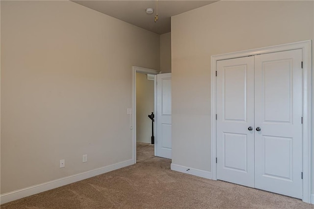 unfurnished bedroom with light carpet and a closet