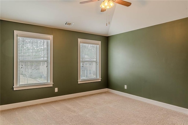 carpeted spare room with vaulted ceiling and ceiling fan