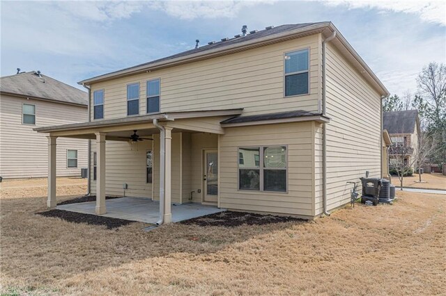 back of house with central AC, ceiling fan, a patio, and a lawn