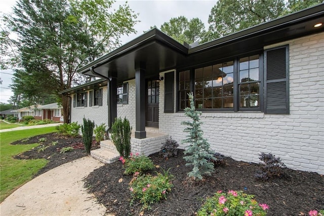 view of exterior entry featuring brick siding