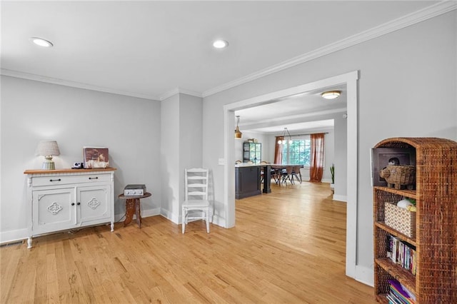 hall with light wood-style floors, crown molding, baseboards, and recessed lighting
