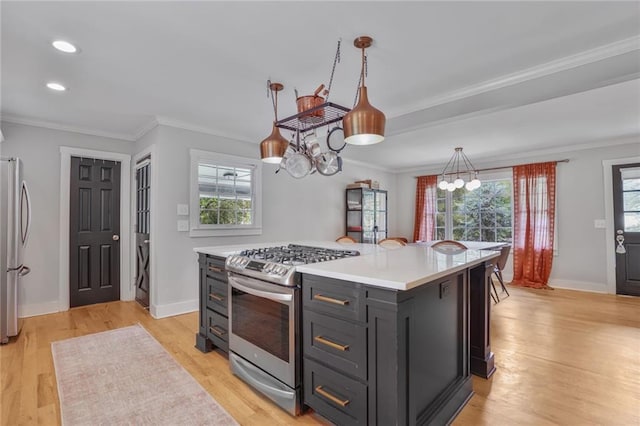 kitchen with stainless steel appliances, light countertops, a chandelier, light wood-style floors, and ornamental molding