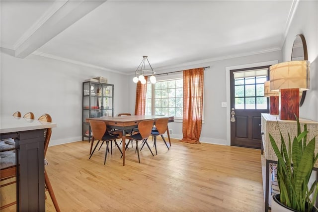 dining area featuring light wood finished floors, baseboards, a chandelier, and ornamental molding