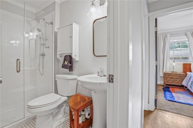 bathroom featuring crown molding, a stall shower, toilet, connected bathroom, and a sink