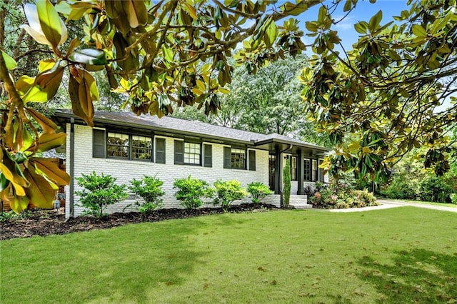 view of front of house featuring brick siding and a front lawn