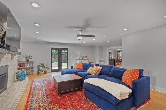 living room with plenty of natural light, a fireplace, recessed lighting, light wood-type flooring, and a ceiling fan