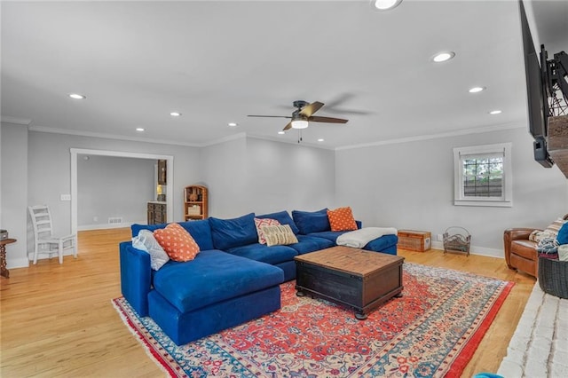 living room with light wood-style flooring, ceiling fan, recessed lighting, baseboards, and crown molding