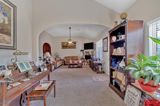 living room featuring a fireplace, lofted ceiling, and light colored carpet