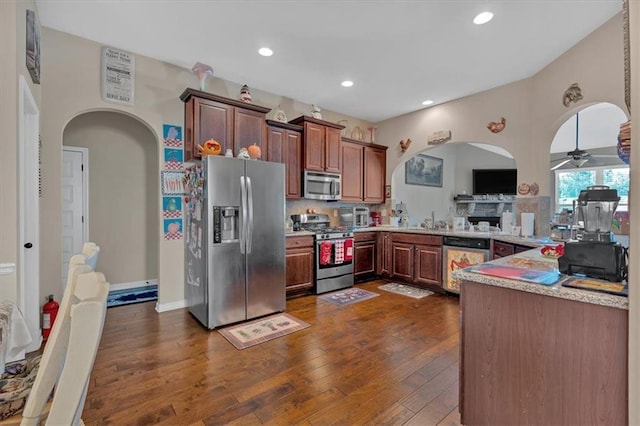 kitchen featuring tasteful backsplash, appliances with stainless steel finishes, sink, dark hardwood / wood-style flooring, and ceiling fan