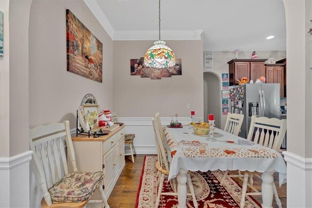 dining room with dark wood-type flooring and crown molding