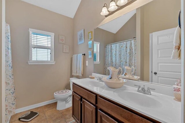 bathroom featuring vanity, lofted ceiling, toilet, and tile patterned floors