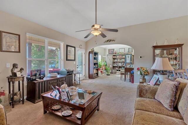 living room featuring ceiling fan, vaulted ceiling, and light colored carpet