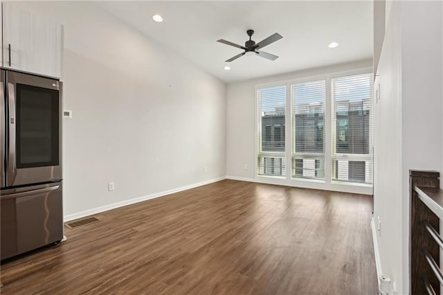 unfurnished living room featuring ceiling fan and dark hardwood / wood-style floors