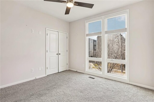 carpeted spare room featuring ceiling fan