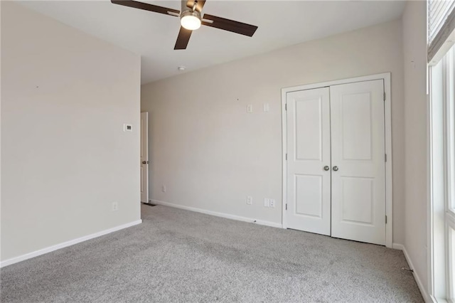 unfurnished bedroom with ceiling fan, a closet, and light carpet