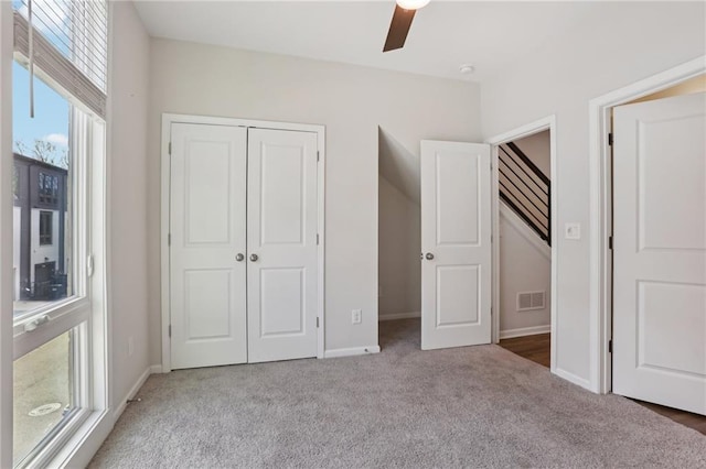 unfurnished bedroom with ceiling fan, a closet, and light colored carpet