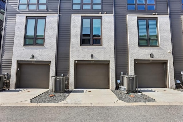 view of property with a garage and central AC unit