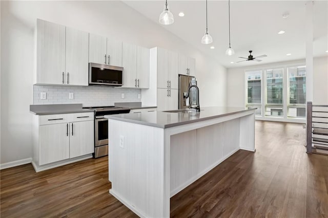 kitchen featuring ceiling fan, sink, hanging light fixtures, appliances with stainless steel finishes, and an island with sink