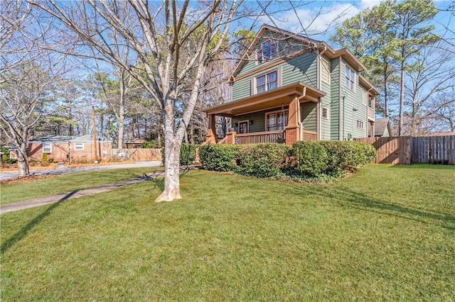 view of front facade featuring a porch, a front yard, and fence