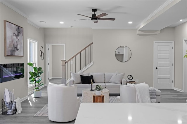 living area with ornamental molding, wood finished floors, and recessed lighting