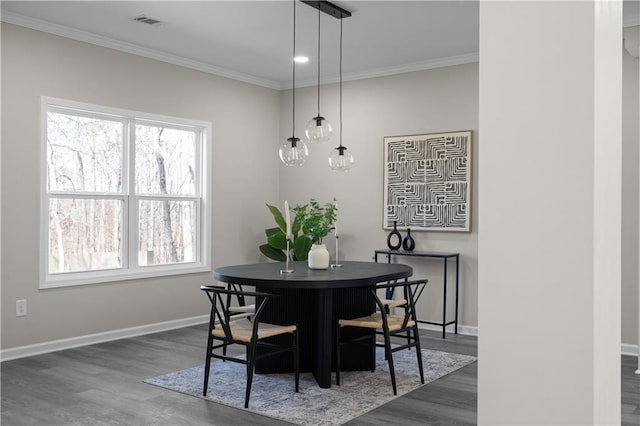 dining area with ornamental molding, dark wood-style flooring, visible vents, and baseboards