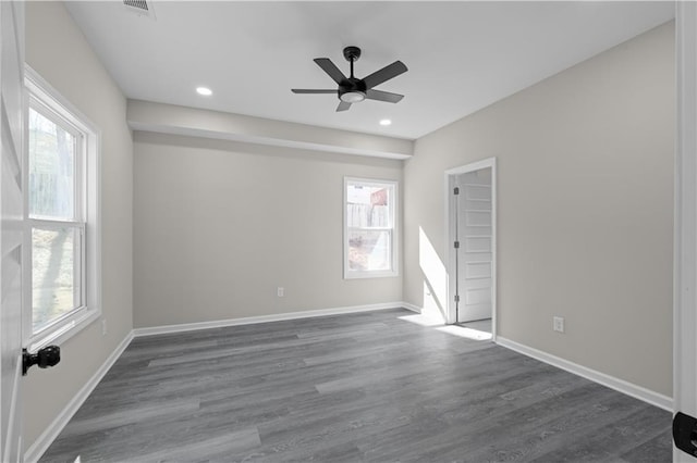 unfurnished room featuring recessed lighting, plenty of natural light, dark wood finished floors, and baseboards