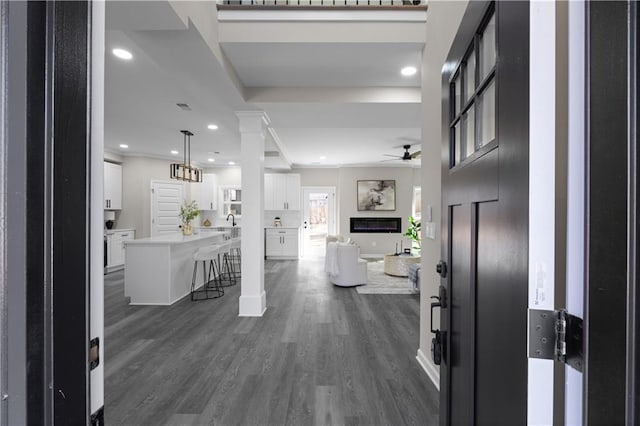 entrance foyer with recessed lighting, visible vents, a ceiling fan, dark wood-style floors, and a glass covered fireplace