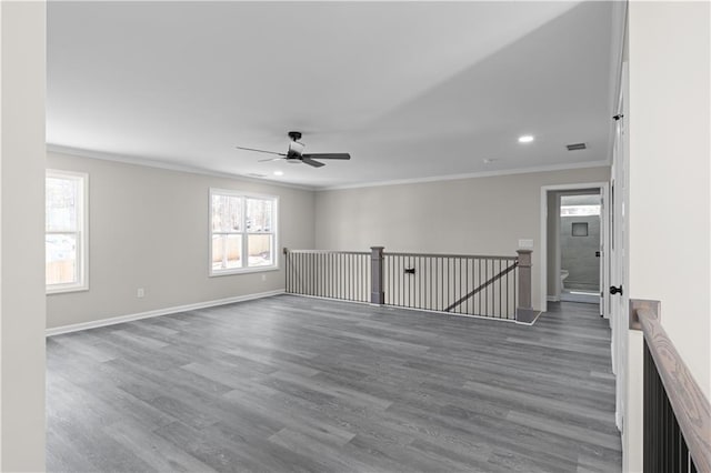 spare room featuring ornamental molding, wood finished floors, and baseboards