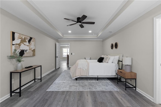 bedroom with a raised ceiling, baseboards, and dark wood-style flooring