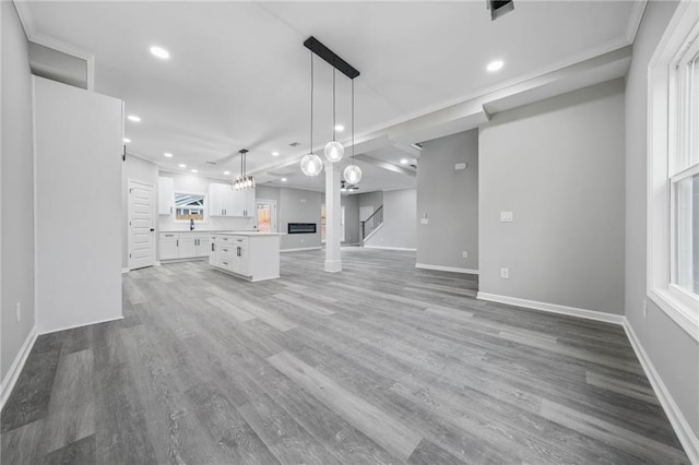 unfurnished living room with stairs, baseboards, wood finished floors, and recessed lighting