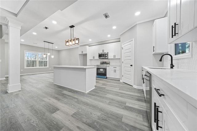 kitchen featuring white cabinets, light wood-style flooring, stainless steel appliances, and a sink