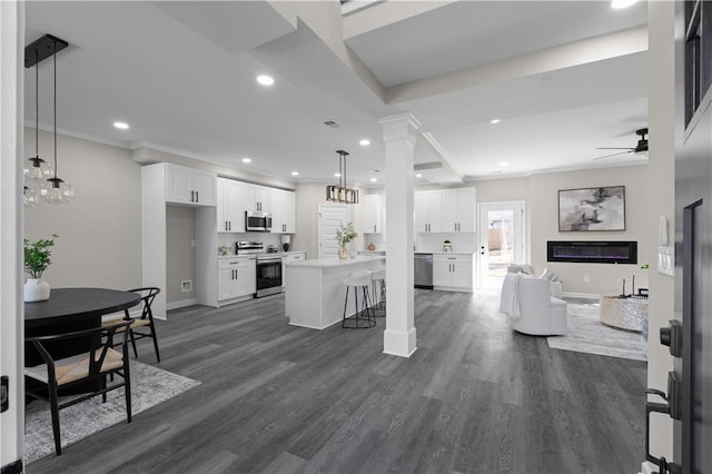 kitchen with open floor plan, appliances with stainless steel finishes, dark wood-type flooring, and white cabinets